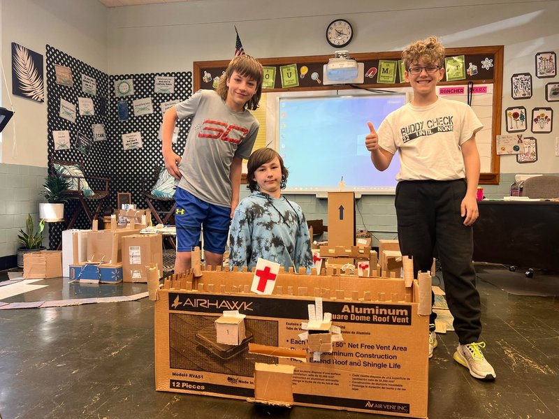 students standing with their cardboard castle