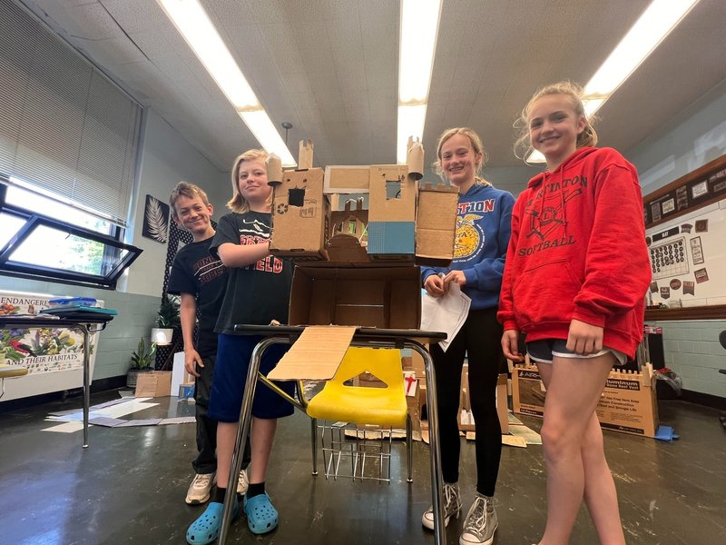 students standing with their cardboard castle